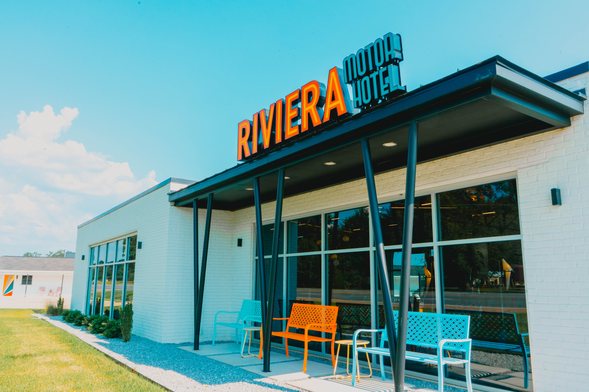 The Riviera Motor Hotel rooftop sign against a bright blue sky