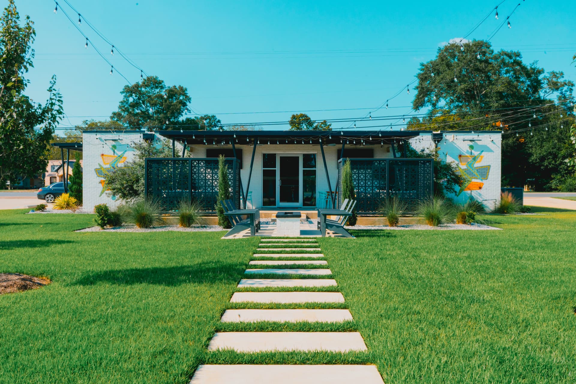 The Riviera courtyard lawn strung with cafe lights at dusk