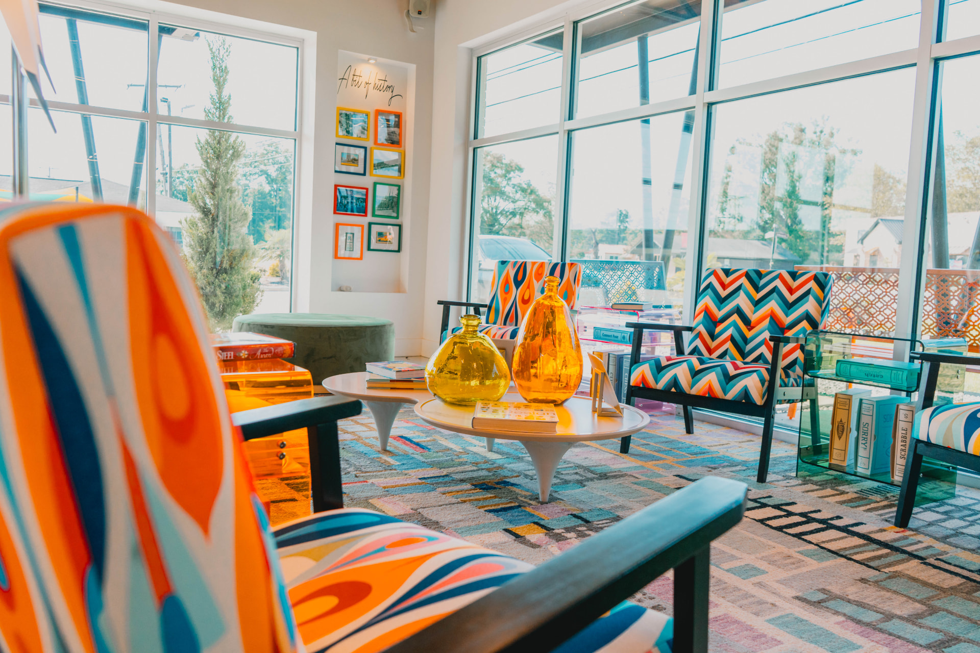 The Riviera lounge with colorful mid-century chairs and floor-to-ceiling windows